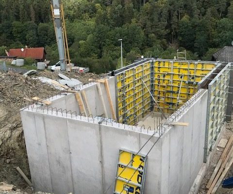 Massive Betonwände mit Resten von Doka-Schalung in einer Baugrube – abgeschlossene Rohbauphase bei Dahl Bau