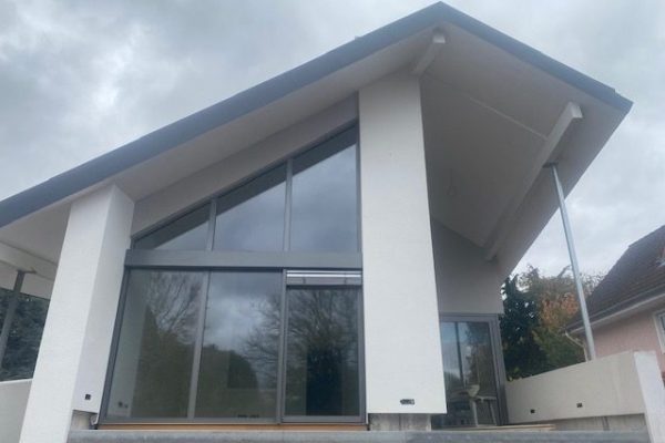Weißes Einfamilienhaus mit großer Glasfassade und modernem Pultdach – neu gebautes Wohnhaus von Dahl Bau