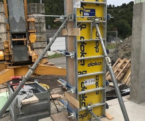Gelbe Doka-Stützenschalung mit Verstrebungen auf einer Baustelle – Vorbereitung für Betonstütze durch Dahl Bau