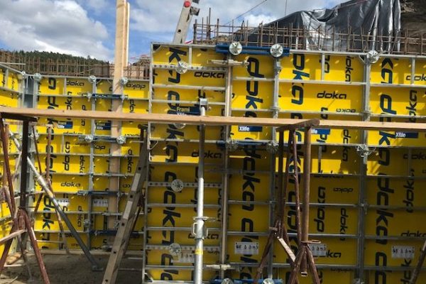 Gelbe Doka-Schalungselemente mit Stützkonstruktion auf Baustelle – Wandvorbereitung für Betonarbeiten